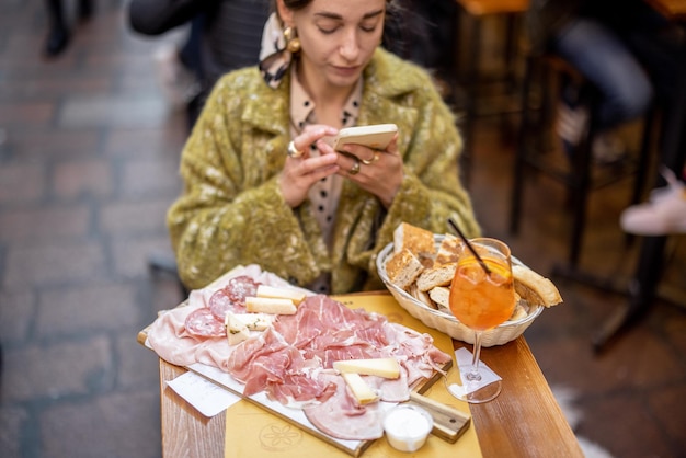 Mulher gosta de gastronomia italiana no restaurante ao ar livre