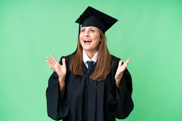 Mulher graduada da universidade de meia-idade sobre fundo isolado com expressão facial de surpresa