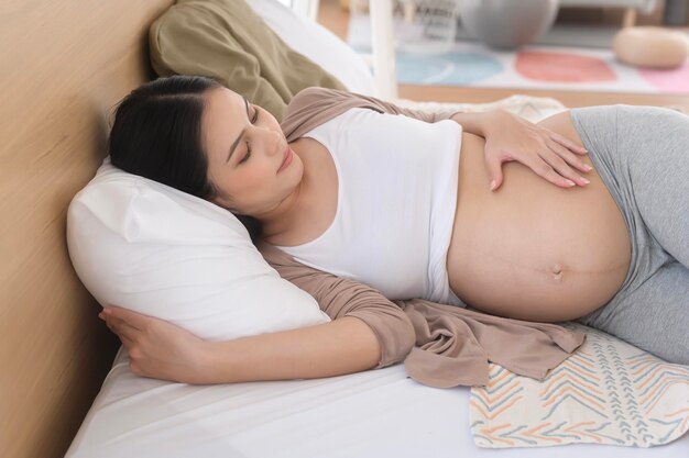 Foto mulher grávida a dormir na cama conceito de gravidez e expectativa