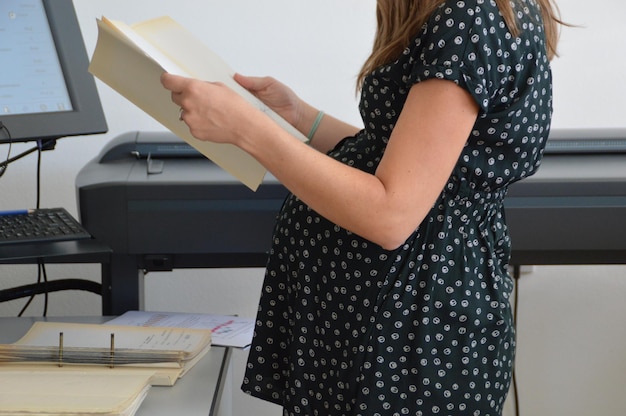 Foto mulher grávida a trabalhar num escritório