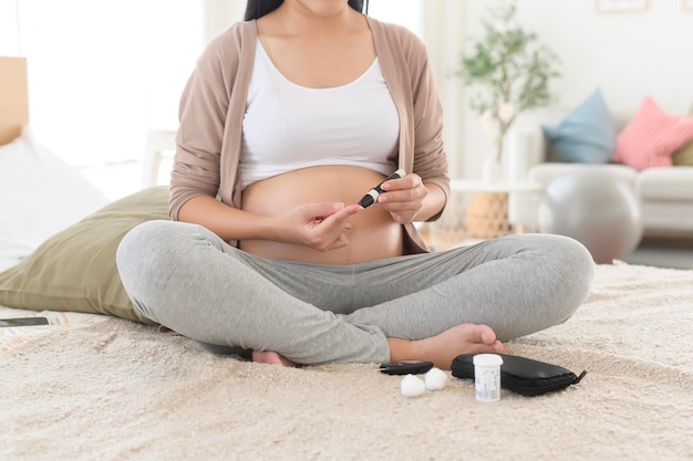 Mulher grávida a verificar o nível de açúcar no sangue usando um medidor de glicose digital