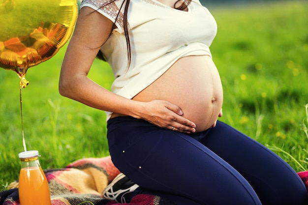 Mulher grávida abraça a barriga