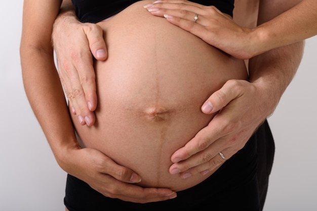 Foto mulher grávida asiática com homem segurando a barriga