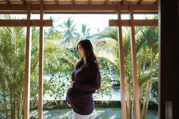 Mulher grávida asiática fica fora de casa