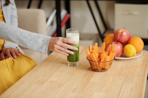 Mulher grávida bebendo suco verde