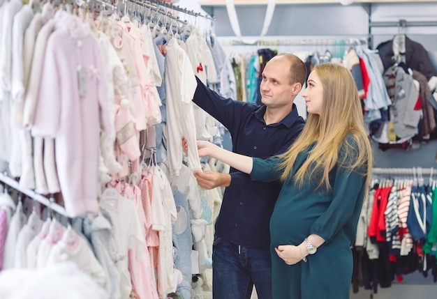 Mulher gravida com marido comprando bebê.