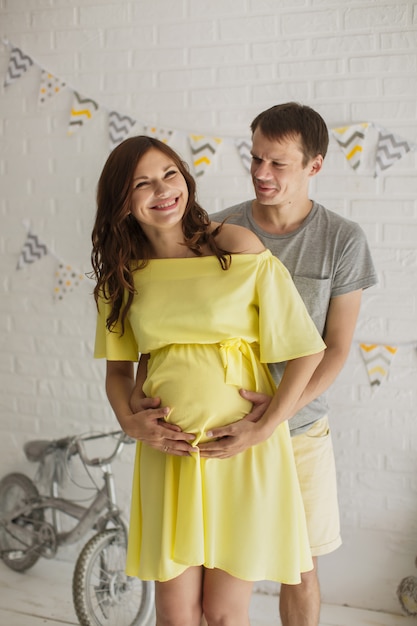 Mulher grávida com o marido no estúdio