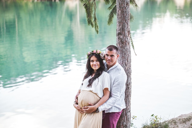 Mulher grávida com o marido no lago