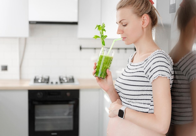 Mulher grávida com pacotes de smoothies verdes de ervas frescas o conceito de alimentos saudáveis e saudáveis para mulheres grávidas