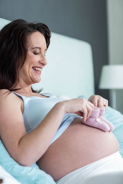 Mulher grávida, com, tricotado, chinelos, ligado, dela, barriga, em, dela, quarto