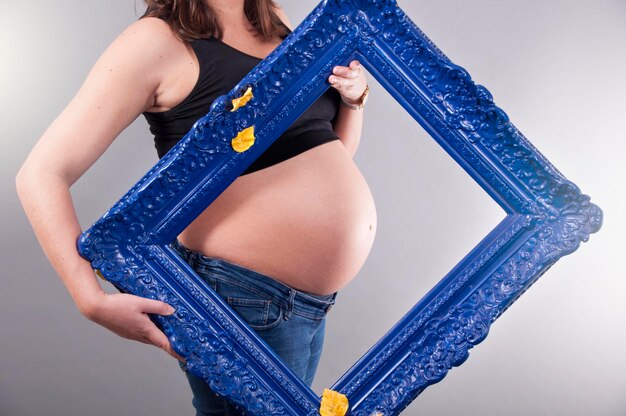 Mulher grávida com um porta-retrato de arte