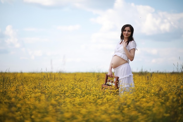 Mulher grávida com um vestido em um campo de flores