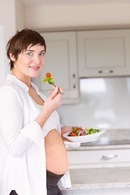 Mulher grávida comendo uma salada