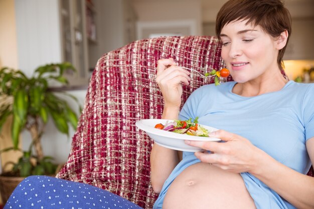 Mulher grávida comendo uma salada