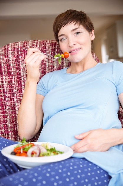 Foto mulher grávida comendo uma salada