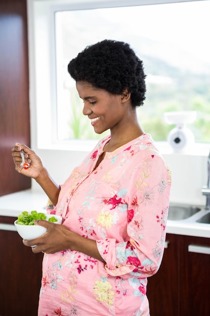 Mulher grávida, comer, salada, em, cozinha