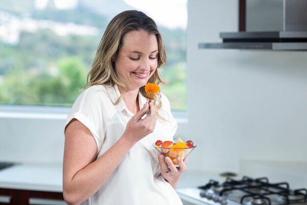 Foto mulher grávida, comer, salada frutas, cozinha