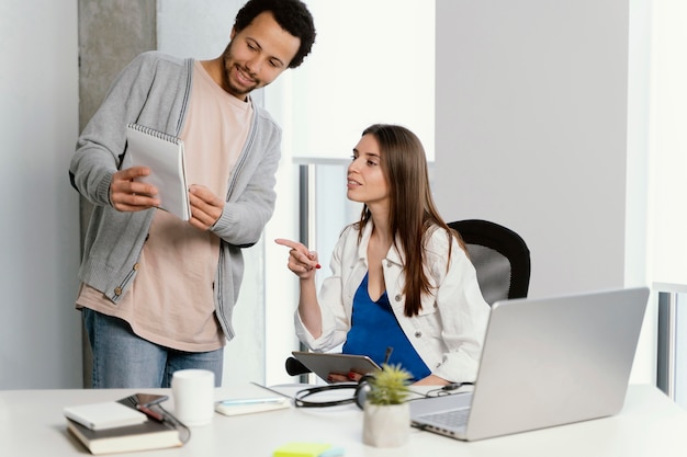 Foto mulher grávida conversando com seu colega de trabalho