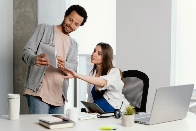 Mulher grávida conversando com seu colega de trabalho