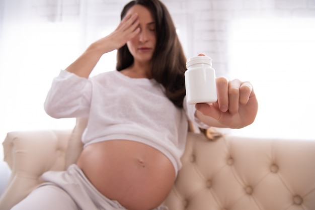 Mulher grávida, é, mostrando, garrafa, com, pílulas