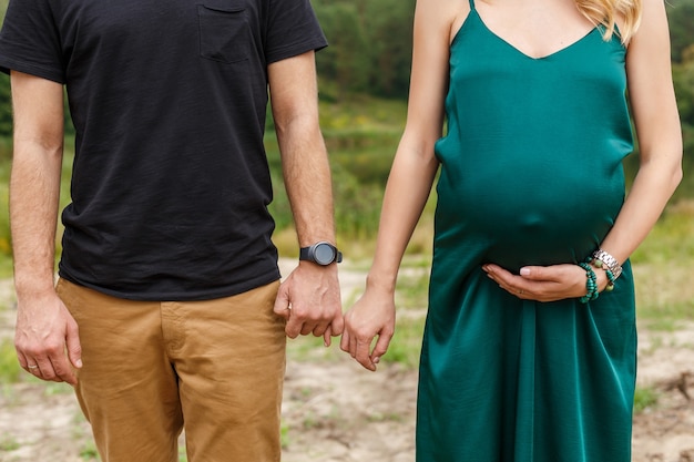 Mulher grávida e o marido de mãos dadas. Fechar foto de gravidez