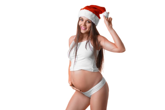 Mulher grávida em lingerie e chapéu de Papai Noel sobre fundo branco