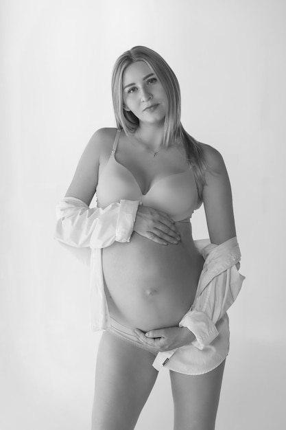Mulher grávida em roupas íntimas no fundo branco