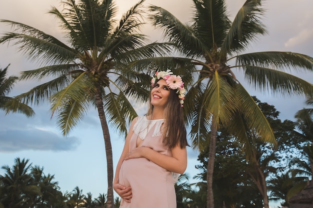 Mulher grávida em um lindo vestido no oceano.