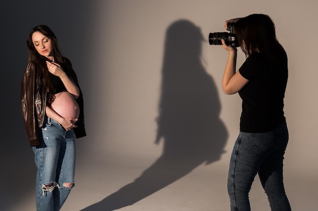 mulher grávida em uma sessão de fotos no processo de estúdio de sessão de fotos Fotógrafo com modelo