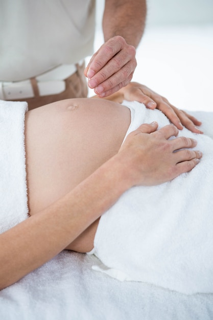 Mulher grávida em uma terapia de acupuntura no spa de saúde