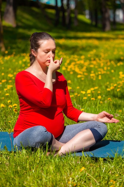 Mulher grávida fazendo exercício de respiração pranayama ao ar livre