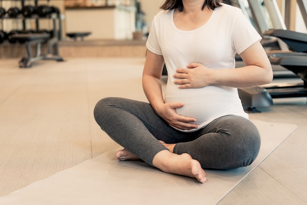 Mulher grávida feliz com bebê na barriga de grávida.