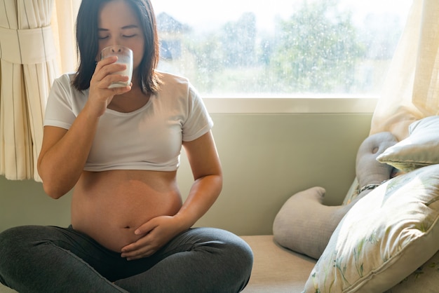 Mulher grávida feliz e bebê à espera.