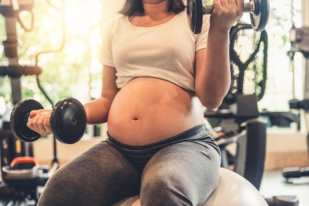 Mulher grávida feliz e bebê à espera.