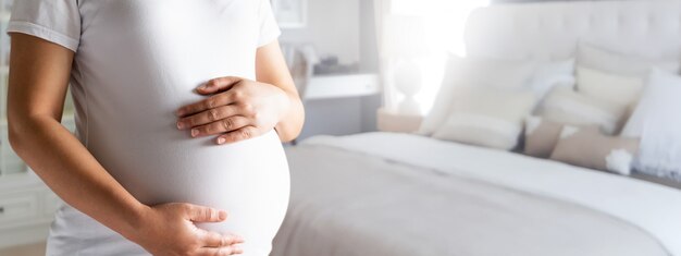 Mulher grávida feliz e bebê à espera.