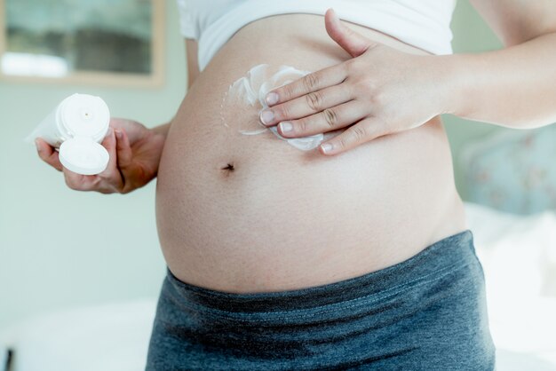 Mulher grávida feliz e bebê à espera.