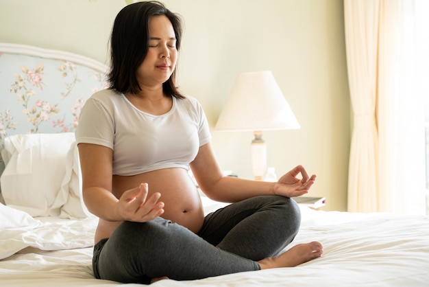 Mulher grávida feliz e bebê à espera.