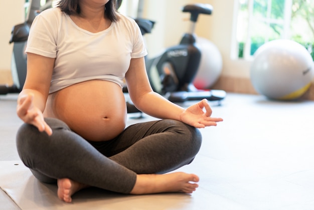 Mulher grávida feliz e bebê à espera.