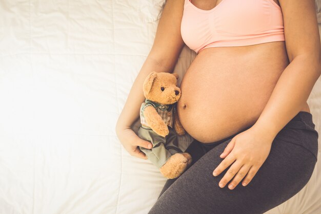 Mulher grávida feliz e bebê à espera.