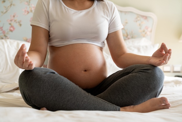 Mulher grávida feliz e bebê à espera.