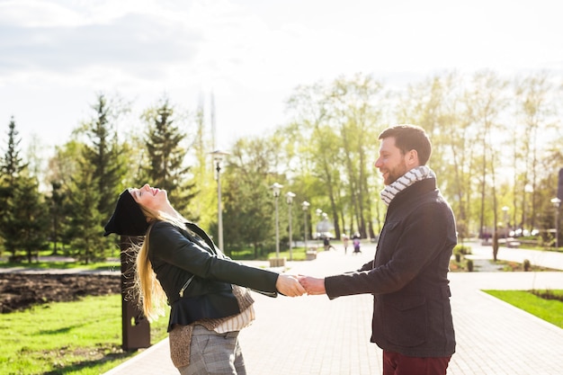 Mulher grávida feliz e o marido no parque.