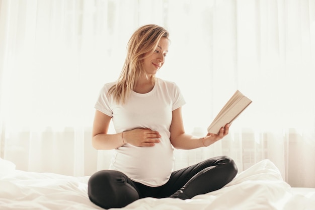 Mulher grávida lendo livro em casa