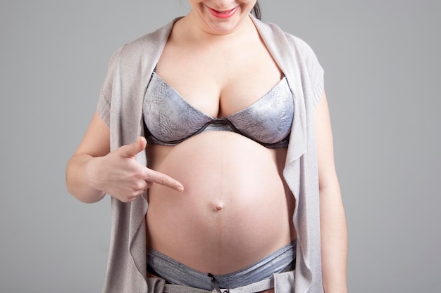 Mulher grávida mostra na barriga