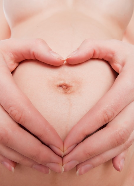 Mulher grávida mostrando sinal de coração