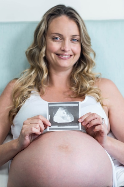 Mulher grávida, mostrando, um, ultrasonografia, mentindo, ligado, dela, cama