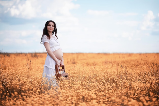 Mulher grávida na natureza para uma caminhada no outono