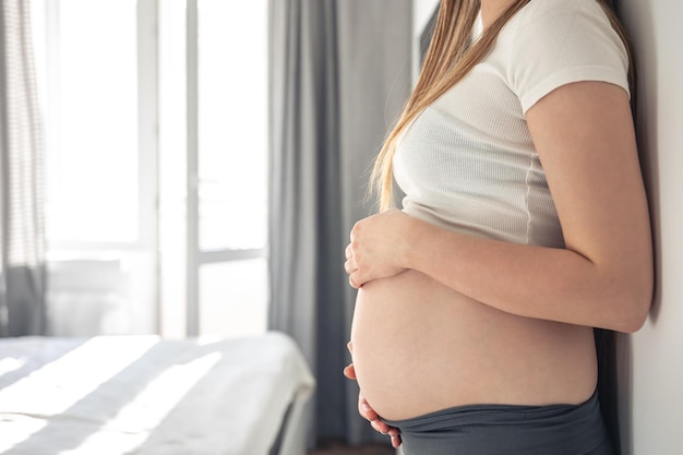 Mulher grávida no interior da sala em um fundo desfocado