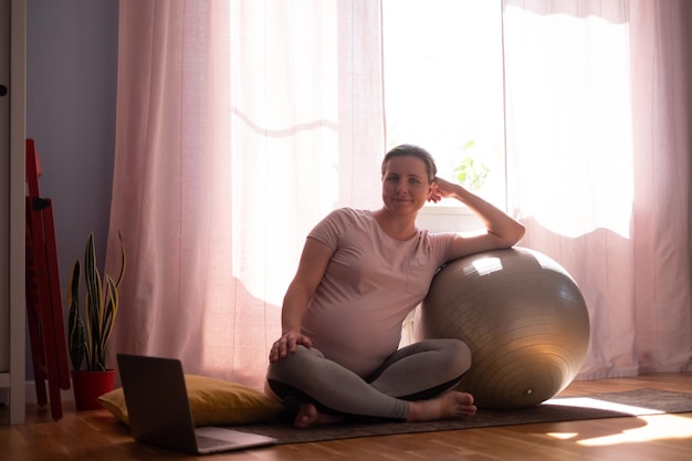 Mulher grávida no treino de esteira de fitness em casa