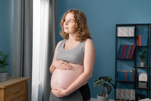Mulher grávida pensativa sonhando com criança jovem feliz expectante pensando em seu bebê
