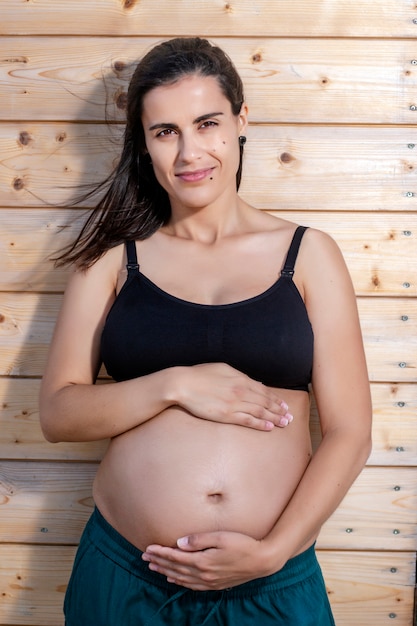 Mulher grávida posa com as mãos na barriga